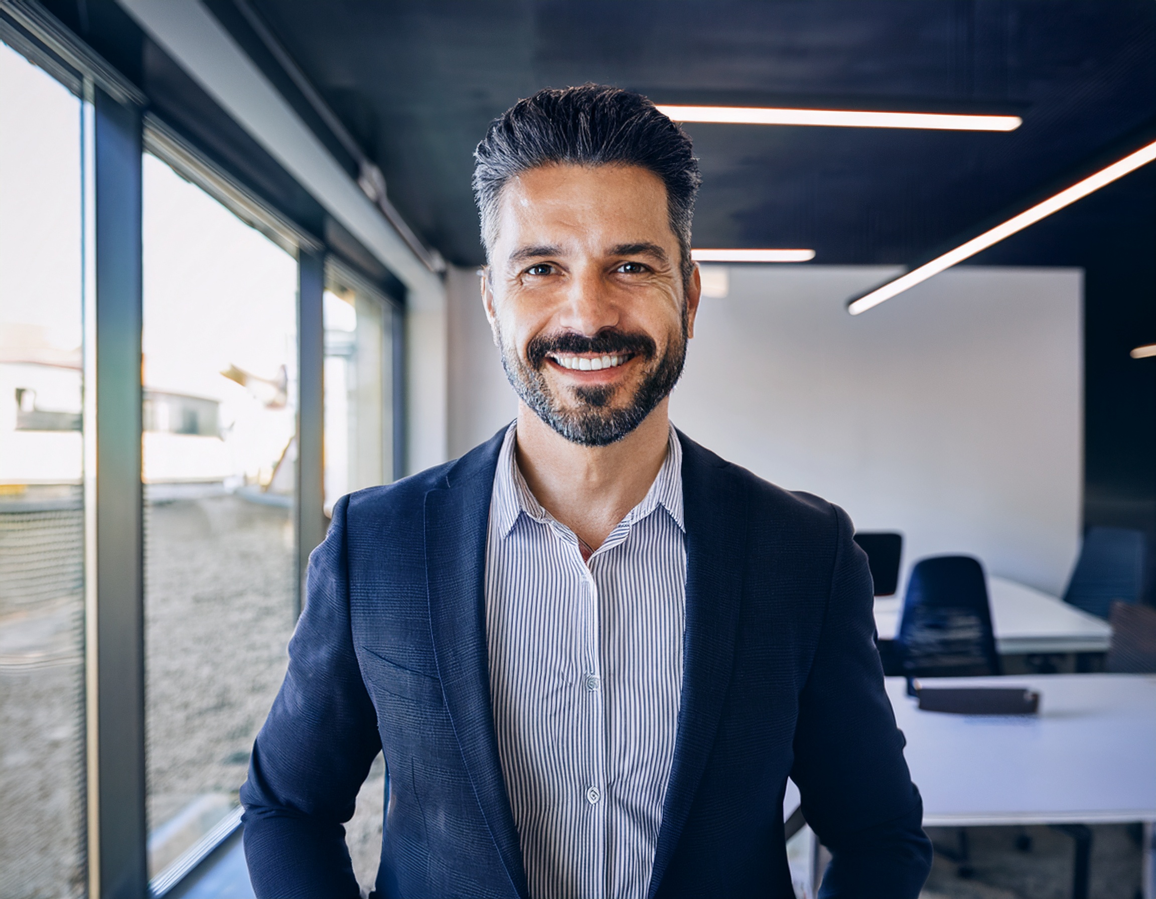 Mann mittleren Alters, freundlich lächelnd, im Business-Outfit